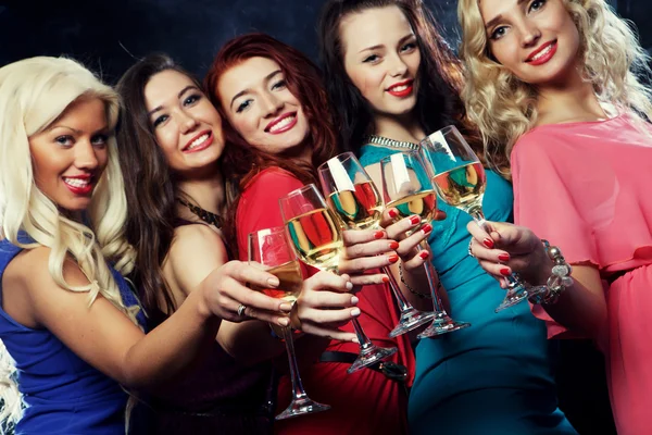 Festande flickor spottar flöjter med mousserande vin — Stockfoto