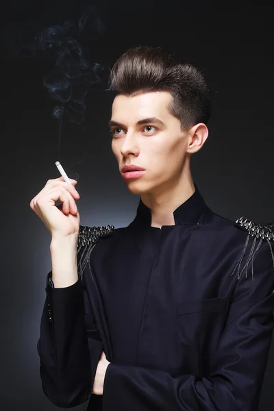 Jovem homem elegante fumar um cigarro — Fotografia de Stock