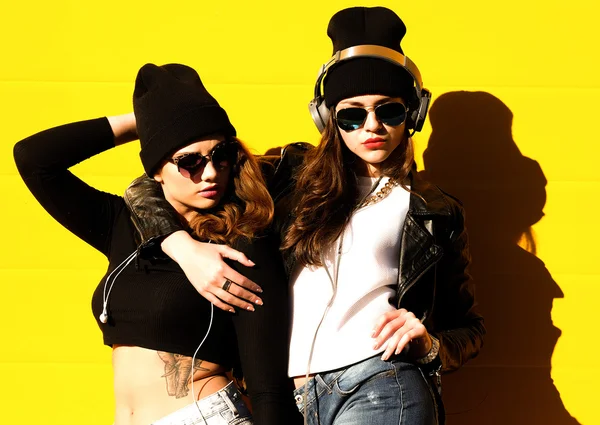 Två unga flickvänner i solglasögon har roligt. — Stockfoto