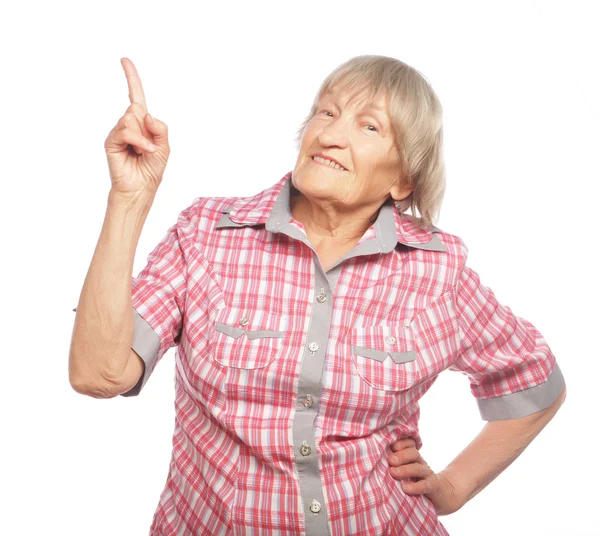 Счастливая пожилая женщина, указывающая вверх — стоковое фото