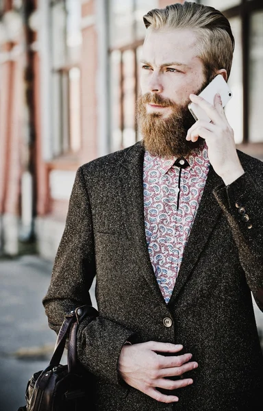 Молодий бородатий чоловік з мобільним, відкритим — стокове фото