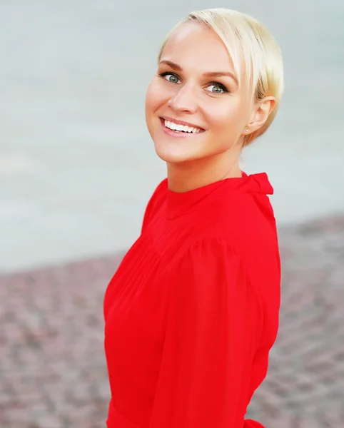 Happy young blond woman, wearing red dress — Stock Photo, Image