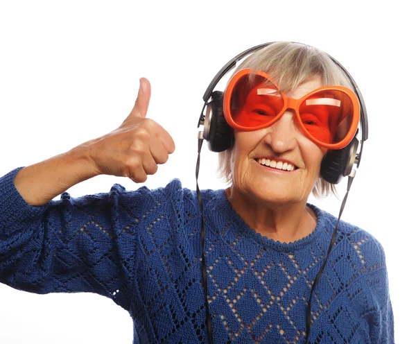 Funny old lady listening music and showing thumbs up. — Stock Photo, Image