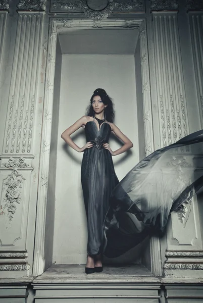 Elegantie vrouw met vliegende jurk in paleis kamer — Stockfoto