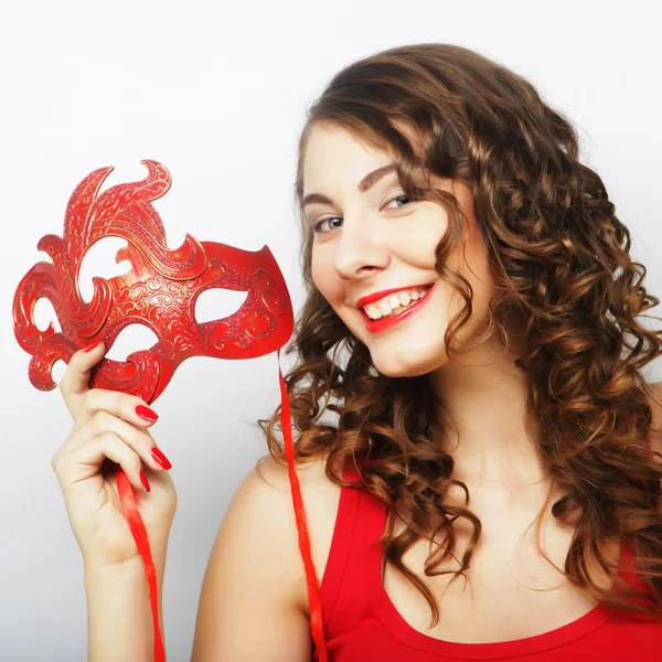 Mujer joven sosteniendo máscara roja — Foto de Stock