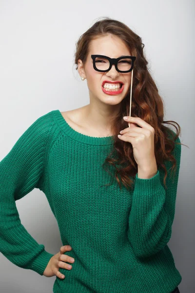 Imagen de fiesta. Mujeres jóvenes juguetonas sosteniendo unas gafas de fiesta . — Foto de Stock