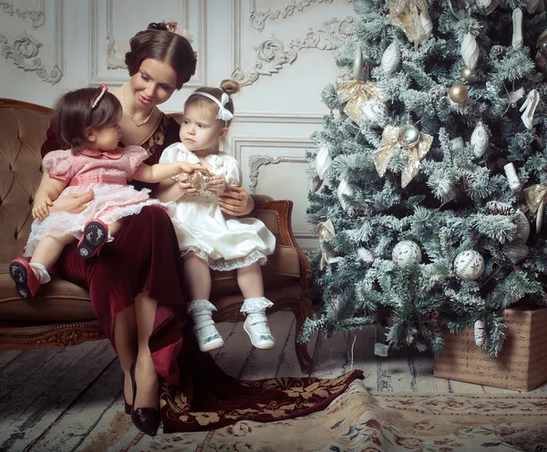 Young mother and her two little daughters near Christmas tree i — Stock Photo, Image