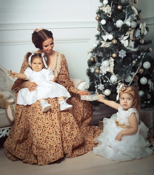 Young mother and her two little daughters near Christmas tree — Stock Photo, Image