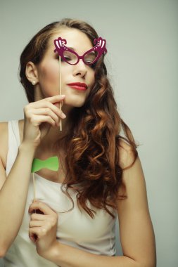 Parti görüntü. Bir parti gözlük tutan oynak genç kadın.