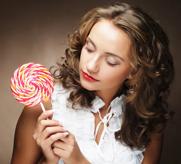 Леденец в руке. Красивая девушка с конфетами . — стоковое фото