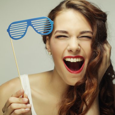 Parti görüntü. Bir parti gözlük tutan oynak genç kadın.