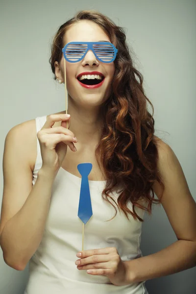 Imagem de festa. Jovens mulheres brincalhões segurando um óculos de festa . — Fotografia de Stock