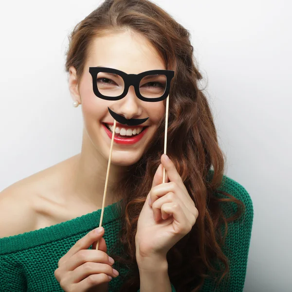 Attractive playful young woman holding mustache and glasses on a — Stock Photo, Image