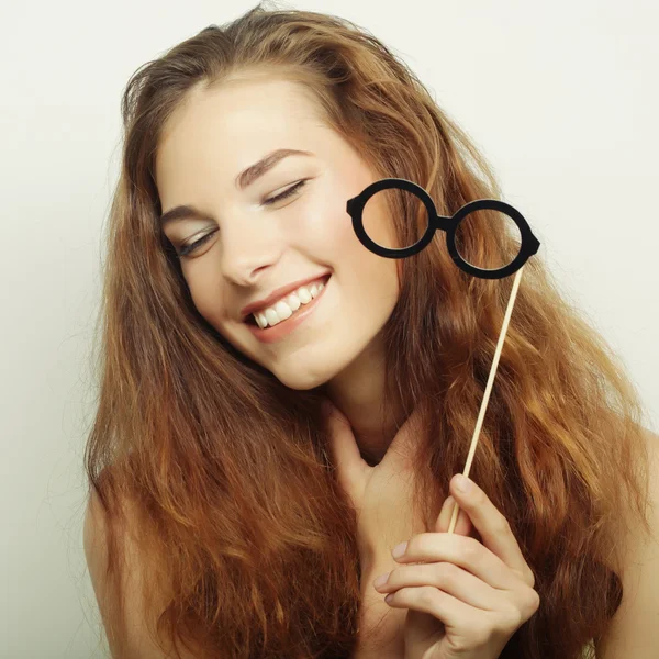 Imagen de fiesta. Mujeres jóvenes juguetonas sosteniendo unas gafas de fiesta . — Foto de Stock