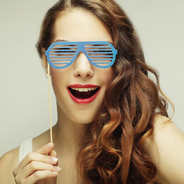 Imagen de fiesta. Mujeres jóvenes juguetonas sosteniendo unas gafas de fiesta . — Foto de Stock