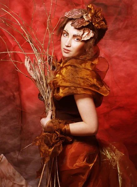 Mulher com brilhante compõem com ramos secos — Fotografia de Stock