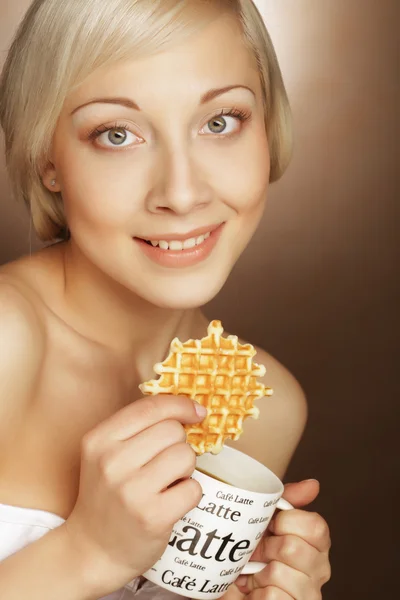 Mujer rubia con café y galletas Imagen de stock