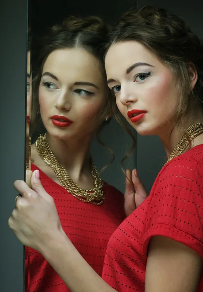 Hermosa chica modelo femenino con maquillaje brillante y su reflejo — Foto de Stock