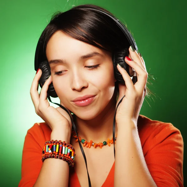 Mujer joven con auriculares escuchando música — Foto de Stock