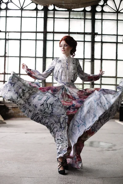 Elegantie vrouw met vliegende jurk in paleis kamer — Stockfoto
