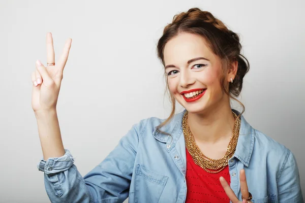 Улыбающаяся красивая молодая женщина показывает большой палец вверх жестом — стоковое фото