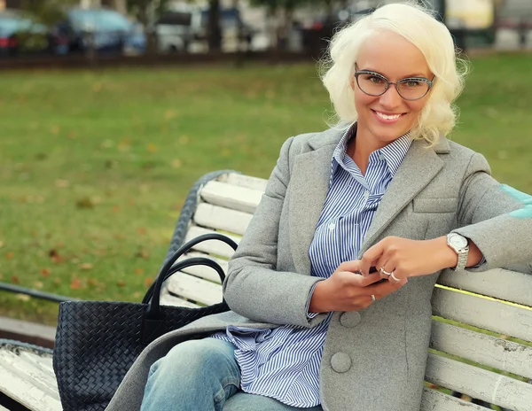 Mujer rubia joven usando un teléfono inteligente — Foto de Stock