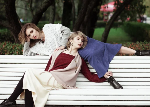 Mladé ženy sedí na lavičce — Stock fotografie