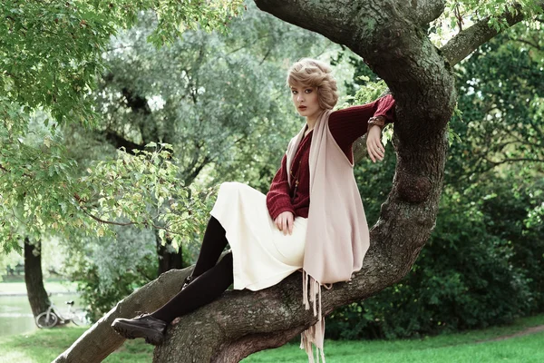 Όμορφη κοπέλα ποζάρει σε ένα δέντρο. — Φωτογραφία Αρχείου