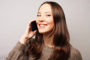 Beyaz bir arka plan üzerinde izole bir cep telefonu kullanan kadın