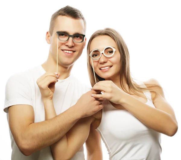 Encantador casal segurando óculos de festa — Fotografia de Stock