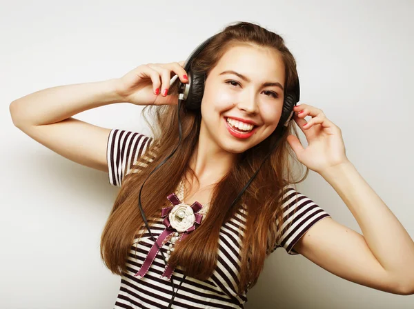 Ung lycklig kvinna med hörlurar lyssnar musik — Stockfoto