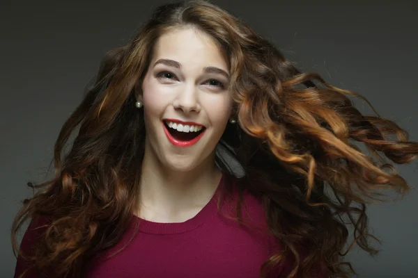 Молодая счастливая женщина с ветром в волосах — стоковое фото