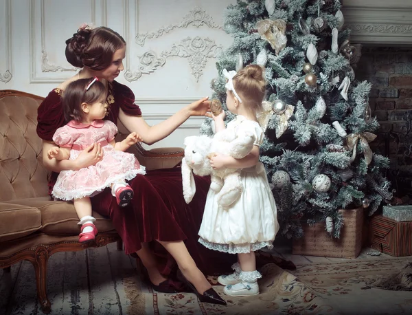Young mother and her two little daughters near Christmas tree — Stock Photo, Image