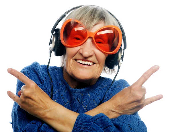 Amuzant bătrână ascultând muzică și arătând degetele în sus . — Fotografie, imagine de stoc