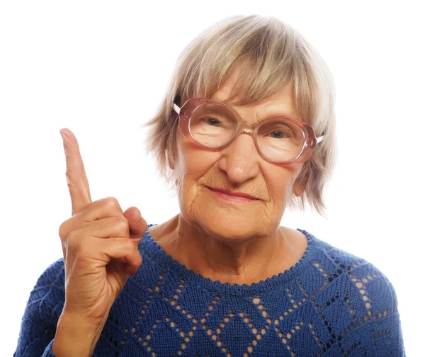 Happy senior woman pointing upwards — Stock Photo, Image