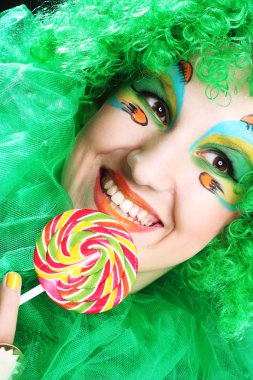 Yaratıcı makyajlı kız lolipop tutuyor