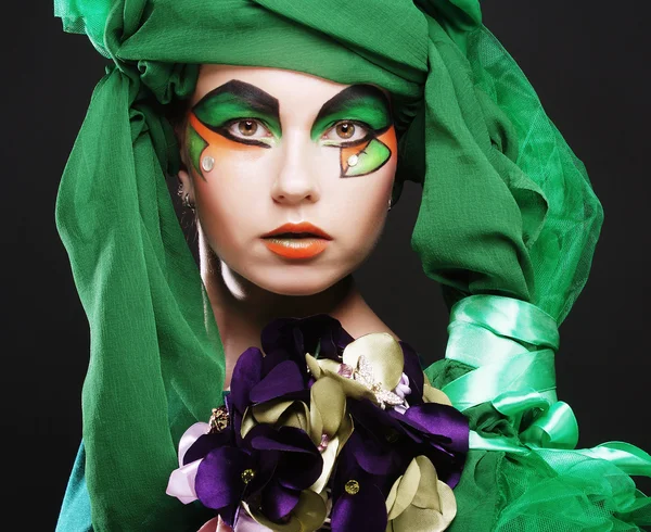 Femme avec maquillage créatif tenant un bouquet de bijoux — Photo