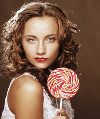 bir lolipop onun elinde olan kıvırcık kız
