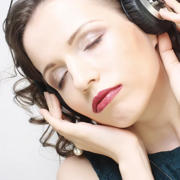 Ung kvinna med hörlurar lyssnar musik — Stockfoto