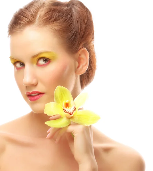 Mladá žena s světlý make-up drží orchidej — Stock fotografie