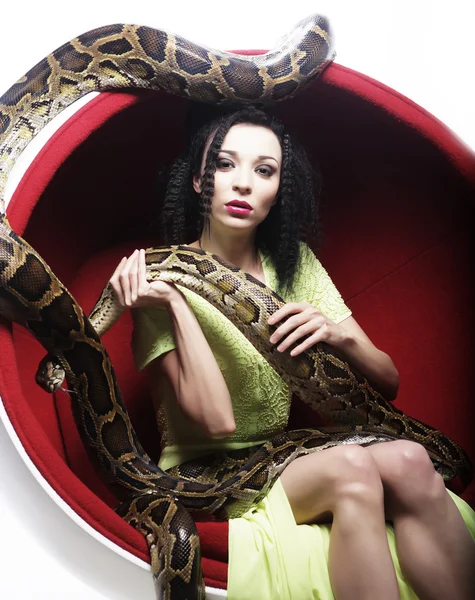 Woman in red chair holdung python — Stock Photo, Image