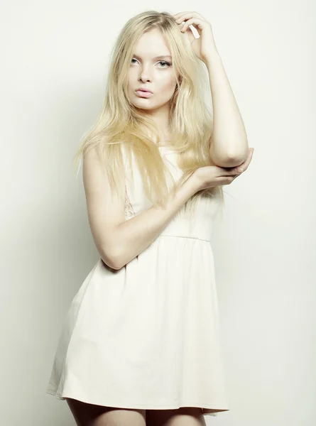 Blond woman in white dress posing in studio Royalty Free Stock Images