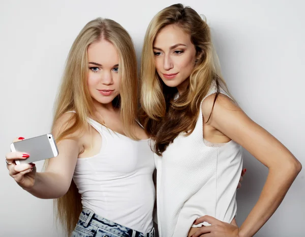 İki genç kadın cep telefonuyla selfie çekiyor. — Stok fotoğraf