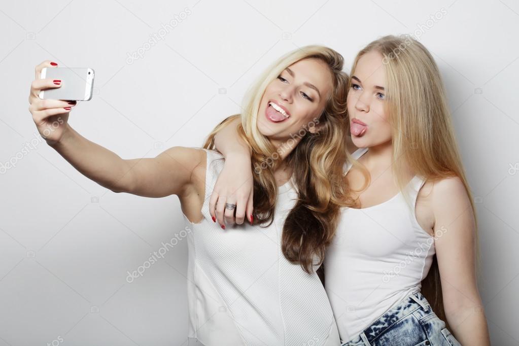 two young women taking selfie with mobile phone