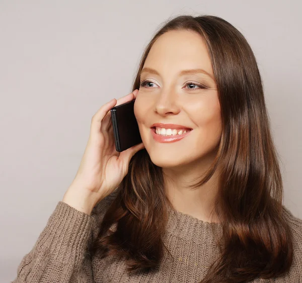 Woman using a mobile phone isolated on a white background — Stock Photo, Image