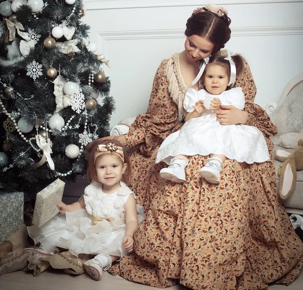 Young mother and her two little daughters near Christmas tree — Stock Photo, Image