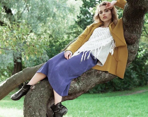 Joven hermosa mujer posando en un árbol . — Foto de Stock