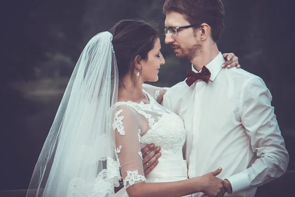 Uma jovem noiva e noivo juntos ao ar livre — Fotografia de Stock