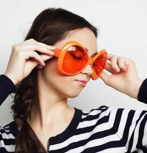 Mujer joven con grandes gafas de sol naranjas — Foto de Stock