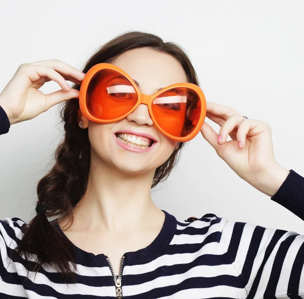 Mujer joven con grandes gafas de sol naranjas — Foto de Stock